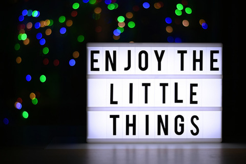 A backlit sign says "Enjoy The Little Things" 