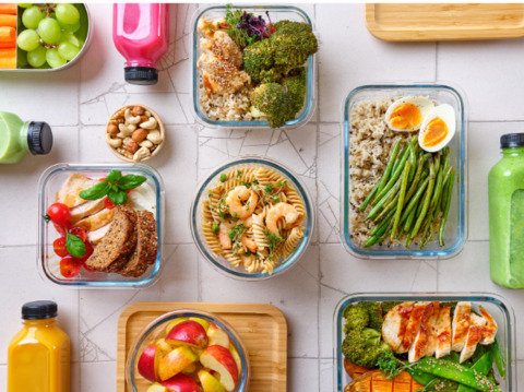 a variety of meals consisting of whole foods in glass containers on a table 