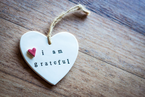 a ceramic ornament in the shape of a heart with the words "I Am Grateful" 
